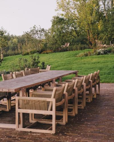 a long wooden table and chairs with a field at The Shepherds Farm in Heuvelland