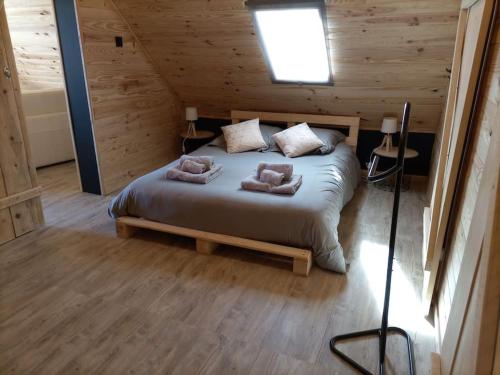 a bedroom with a bed with two pillows on it at Gîte l'estive du Clozel in Besse-en-Chandesse