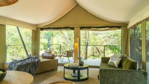 a living room with a couch and a tent at Mbizane Escarpment Retreat in Schoemanskloof