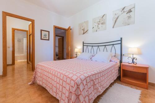 a bedroom with a bed with a red and white blanket at Villa Can Llinàs in Sencelles