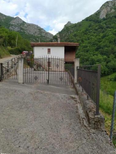 a gate in front of a building on a mountain at CASA TABLADO HELENA in Belmonte de Miranda