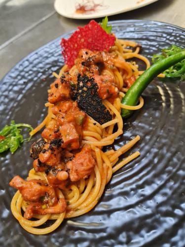 a plate of food with noodles and meat on it at La Bussola Hotel Calabria in Capo Vaticano