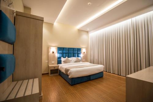 1 dormitorio con 1 cama con cabecero azul en Granada Palace Inn en Riad