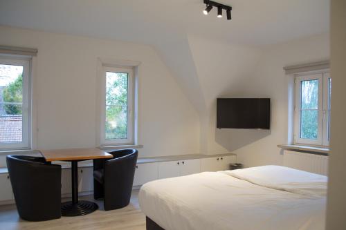 a bedroom with a bed and a desk and a table at Hotel Swaenenburg in Oostrozebeke