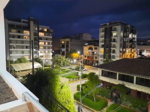 a view of a city at night with buildings at Waraqu Wasi Hermoso y acogedor departamento,zona residencial in Cusco