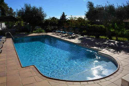 ein großer Pool mit Stühlen im Hof in der Unterkunft Villa Lluna Sitges 15 minutes drive from Sitges Swimming pool XXL 16 people in Olivella