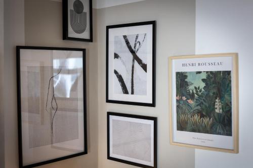 a group of framed pictures hanging on a wall at Stoneholme Short Stay - Clare Street Apartments in Blackpool