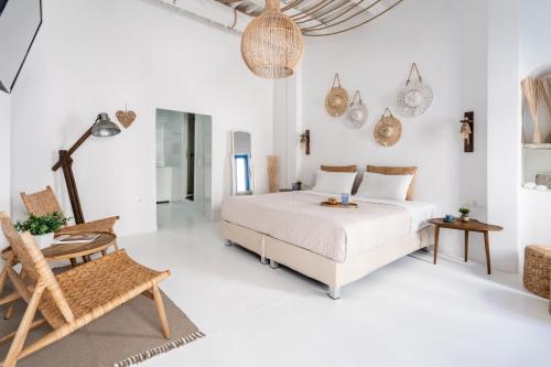 biała sypialnia z łóżkiem i krzesłem w obiekcie Love suite mykonos town w mieście Mykonos