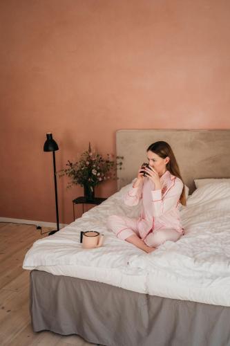 a girl sitting on a bed talking on a cell phone at Villa Huno in Borre