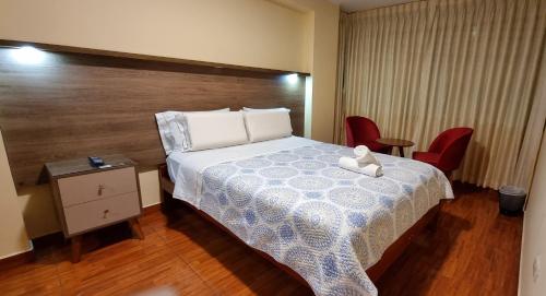 a bedroom with a bed with a teddy bear on it at Lembranças Hotel in Huánuco