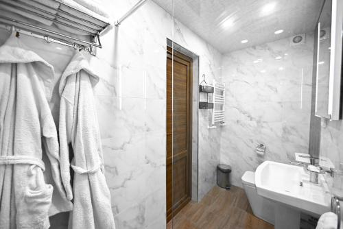 a white bathroom with a sink and a toilet at Aurelia Hotel & Restaurant in Dilijan