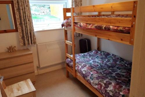 1 dormitorio con 2 literas y ventana en Welsh holiday home sleeps 5 close to beaches & mountains en Nantlle