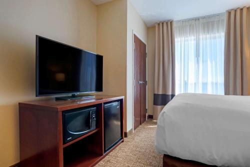 a hotel room with a flat screen tv and a bed at Comfort Suites Foley - North Gulf Shores in Foley