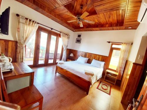 sypialnia z łóżkiem i wentylatorem sufitowym w obiekcie Viet Thanh Resort w Duong Dong