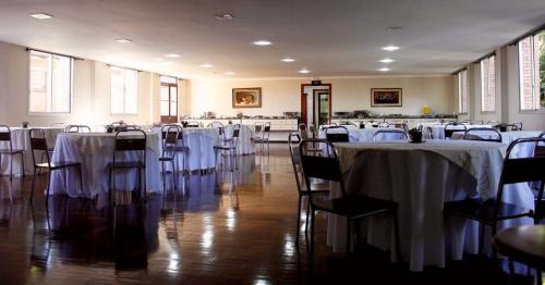 a room filled with tables and chairs with white table cloth at Vila Betânia in Porto Alegre