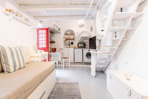 a white apartment with a spiral staircase in a room at Little house town mykonos in Mikonos