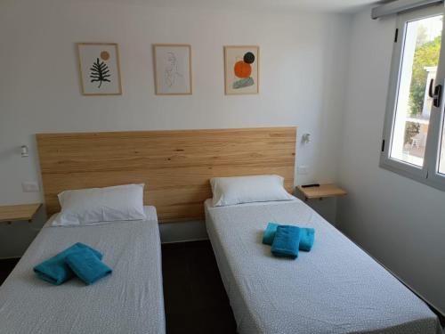 two beds in a room with blue pillows on them at Complejo Sun's Gardens - Maspalomas in Maspalomas