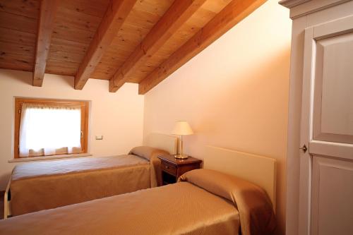 a bedroom with two beds and a window at Residence Borgo Mondragon in Lazise
