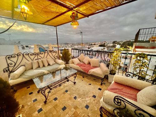 einen Balkon mit Sofas und Blick auf das Wasser in der Unterkunft DAR ADIL KASBAH in Tangier