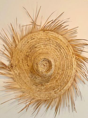a straw hat hanging on a wall at DAR ADIL KASBAH in Tangier