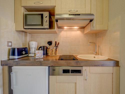 a small kitchen with a sink and a microwave at Vacancéole – Le Domaine de Camiole in Callian