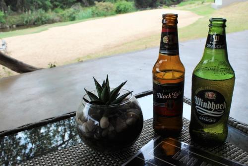 two bottles of beer sitting on a table at Lions Rock Rapids - Luxury Tented Camp in Hazyview