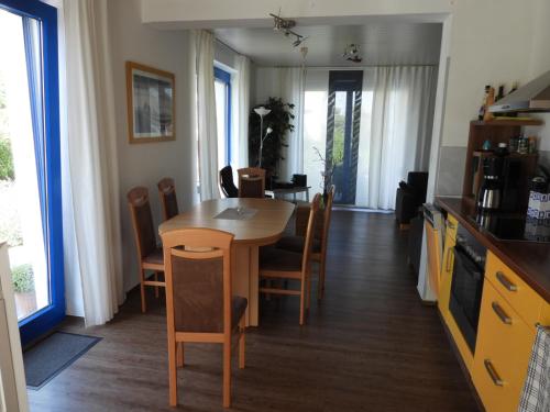 a kitchen and dining room with a table and chairs at Bodden-Adler in Fuhlendorf