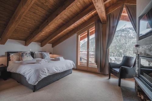 a bedroom with a bed and a large window at Chalet Jessica in Saas-Fee
