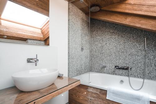 a bathroom with a sink and a bath tub at Chalet Jessica in Saas-Fee