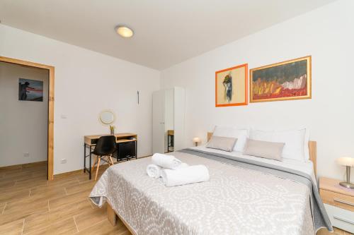sypialnia z łóżkiem z białą pościelą i biurkiem w obiekcie Rooms FOREVER w mieście Miholašćica