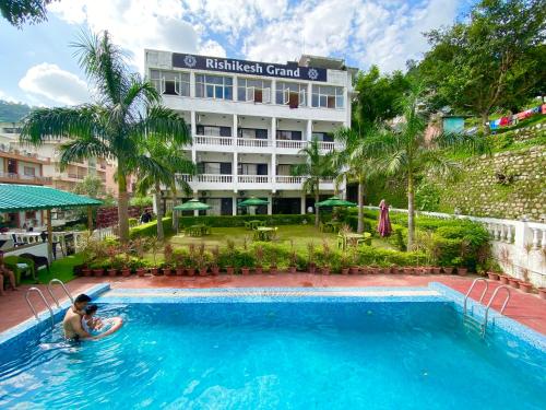 un hombre en una piscina frente a un hotel en Hotel Rishikesh Grand by Kool-Stays, en Rishīkesh