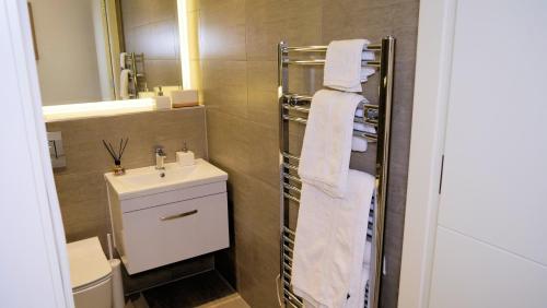 La salle de bains est pourvue d'un lavabo et d'une serviette blanche. dans l'établissement Luxurious Short Stay Flat in Milton Keynes, à Milton Keynes