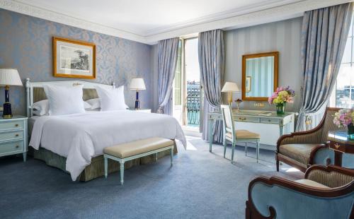 a bedroom with a bed and a desk and a mirror at Four Seasons Hotel des Bergues Geneva in Geneva