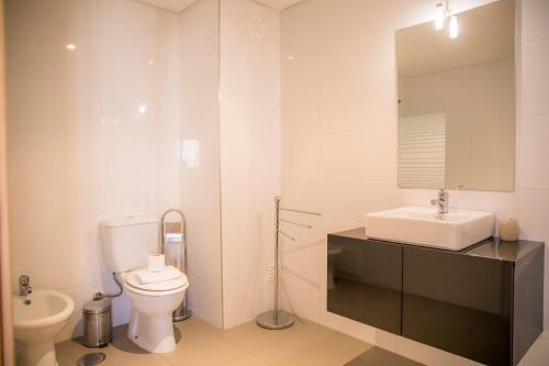 a white bathroom with a sink and a toilet at A17 - Heaven Sun Praia da Rocha 1 Bed Apartment in Portimão