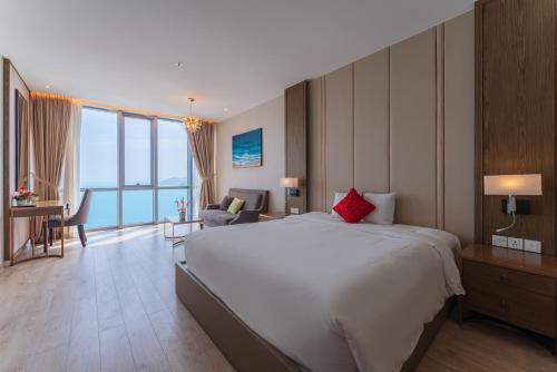 a hotel room with a large bed and a desk and chair at SeaHaven Panorama Nha Trang Superview Apartments in Nha Trang