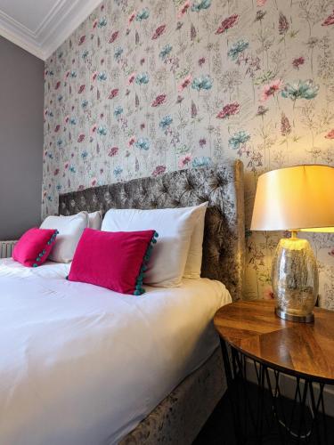 a bedroom with a bed and a table with a lamp at Blue Keys Hotel Southampton in Southampton