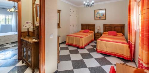 アルコス・デ・ラ・フロンテーラにあるVILLA RAQUELのチェッカーフロアのベッドルーム1室(ベッド2台付)