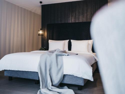 a bedroom with a large bed with white sheets at The Crystal VAYA Unique in Obergurgl