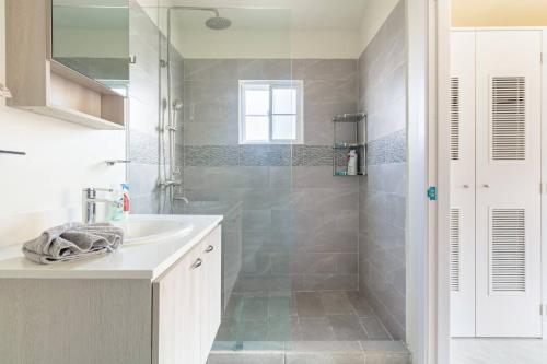 a bathroom with a sink and a shower at Brand New - Bungalow - Ocean View - Discovery Bay in Discovery Bay