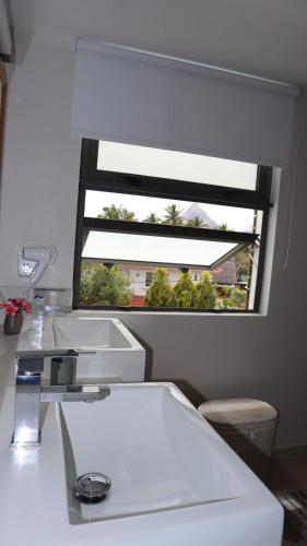 a bathroom with two sinks and a window at Sunset Beachfront Penthouse Cap Ouest Flic en Flac in Flic-en-Flac