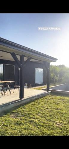 a pavilion with a table and chairs at Villa a vamos 