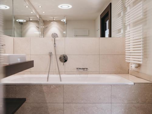 a bathroom with a tub and a sink at The Crystal VAYA Unique in Obergurgl
