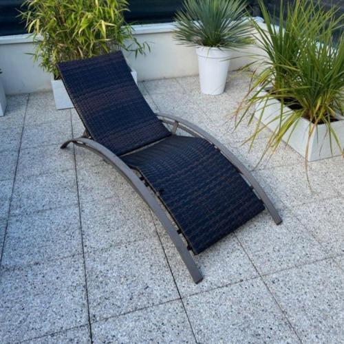 une chaise bleue assise sur une terrasse ornée de plantes dans l'établissement Appartement Rdc avec parking privé, à Bastia