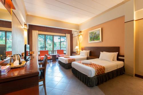 een hotelkamer met 2 bedden en een bureau bij ปานเทล เขาใหญ่ Parntel KhaoYai in Khao Yai