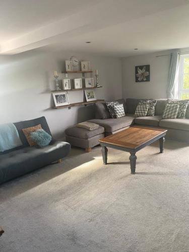 a living room with a couch and a coffee table at Upstairs river apartment in Gloucester