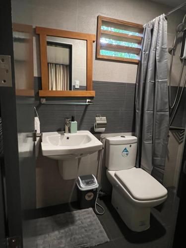 a small bathroom with a toilet and a sink at Happy Camper Hostel in Coron
