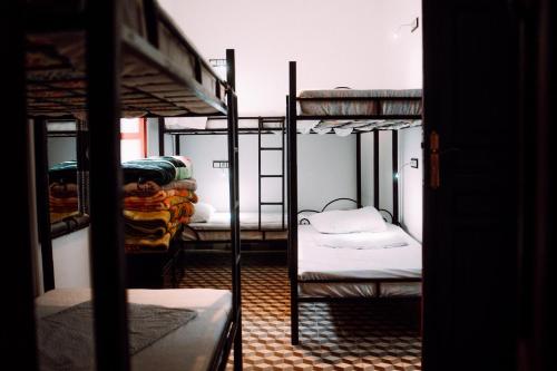 a room with three bunk beds in a room at The Riad Hostel Tangier in Tangier