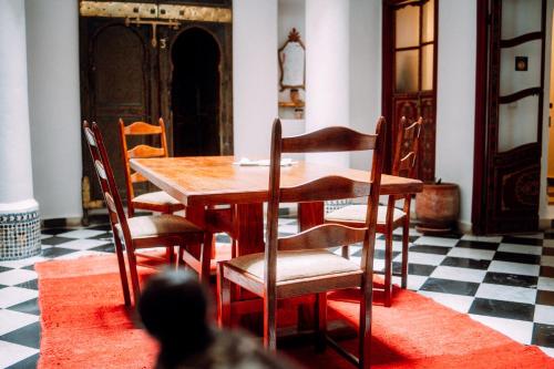 una sala da pranzo con tavolo e sedie in legno di The Riad Hostel Tangier a Tangeri