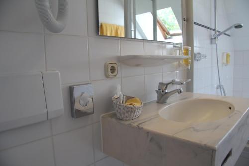 La salle de bains est pourvue d'un lavabo et d'un miroir. dans l'établissement Abasto Hotel Eichenau, à Eichenau