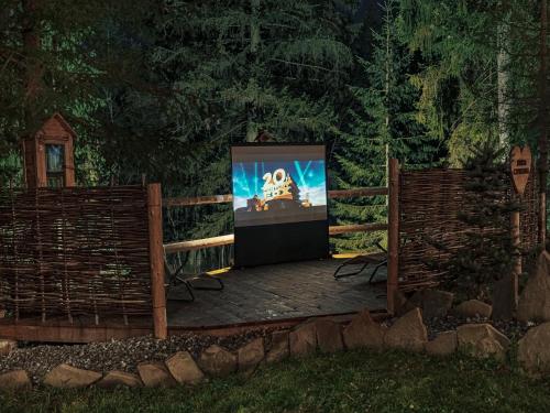 a screened in porch with a television in a yard at Zagroda Krowiarki Chochołów in Chochołów